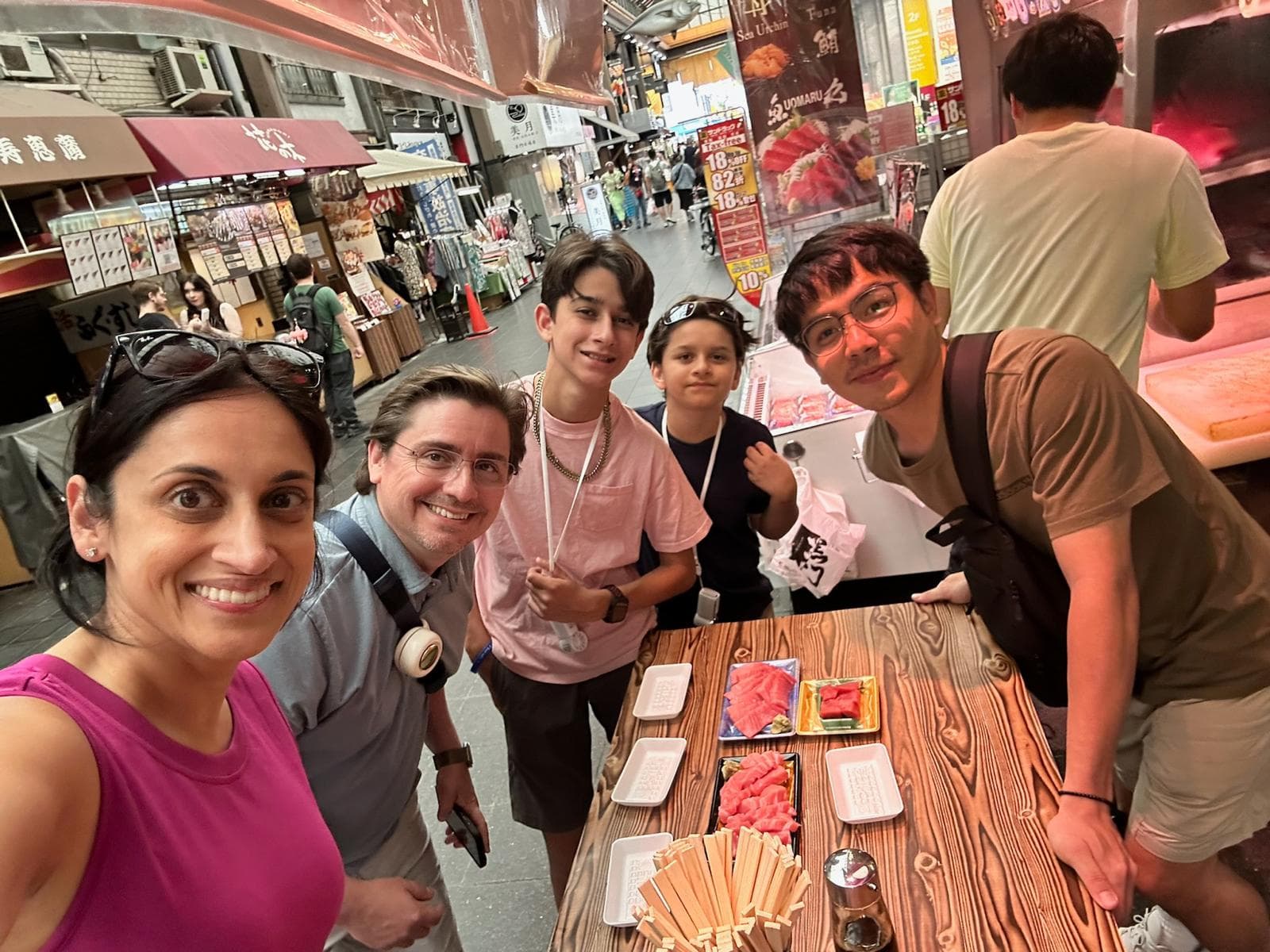 Guests sharing fresh food at a market during an Osaka walking tour